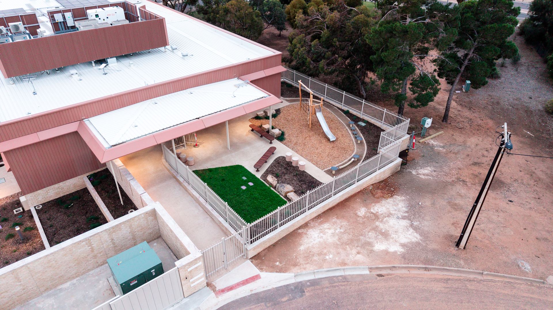 Aerial view of the side of the RFDS facility, with a fenced play area and landscaping